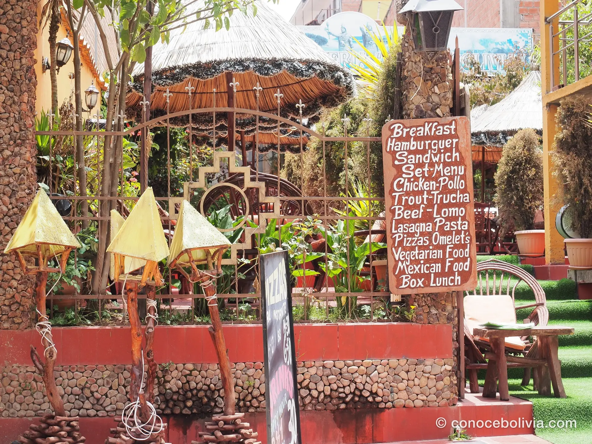 Cartel de menú con desayuno, hamburguesas y comida vegetariana en una terraza de Copacabana