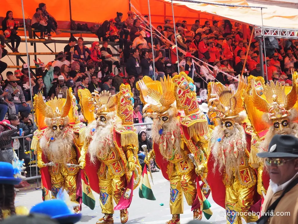 Bailarines con máscaras doradas y tocados ornamentados en el Carnaval de Oruro