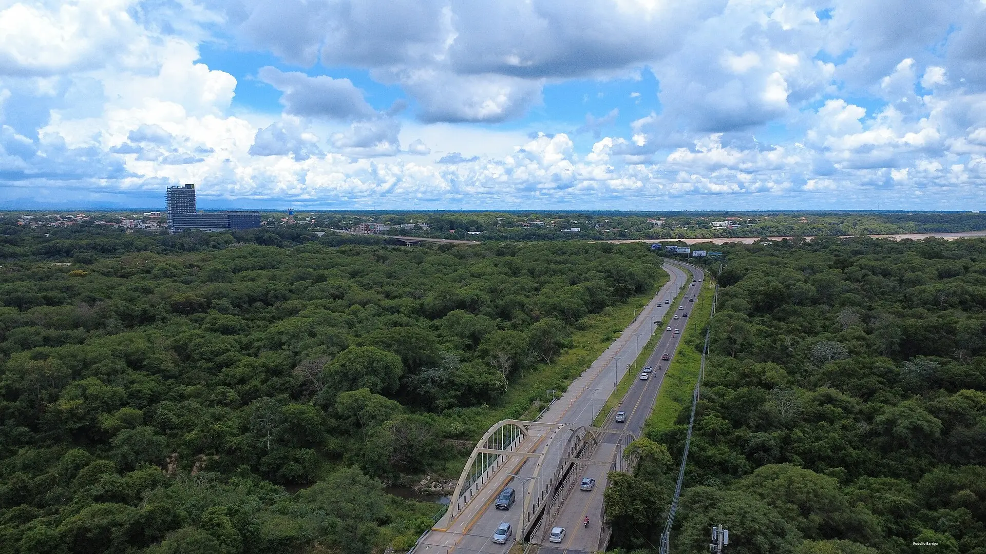 Vista aérea de la carretera hacia el Urubó cruzando el río Piraí entre la selva