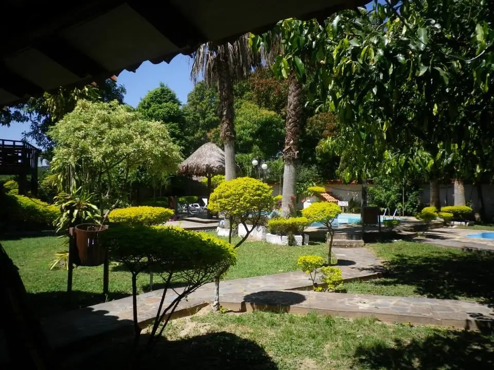 Piscina entre jardines y palmeras en un balneario de Porongo