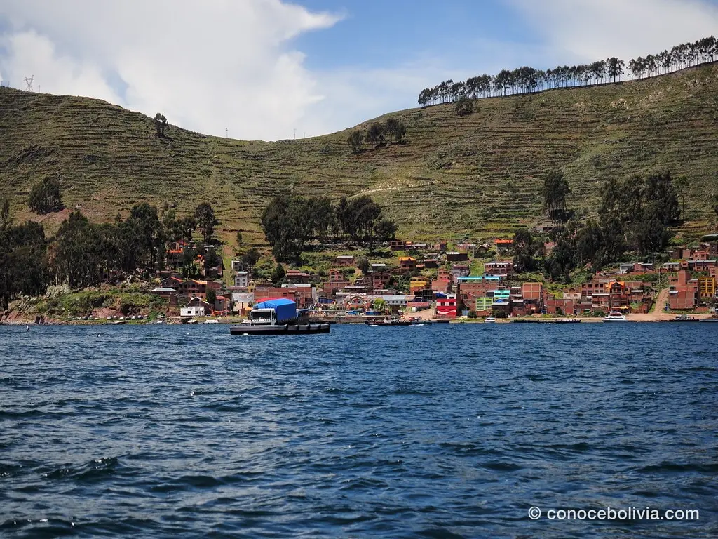Bahía con pueblo entre colinas terraceadas junto al lago