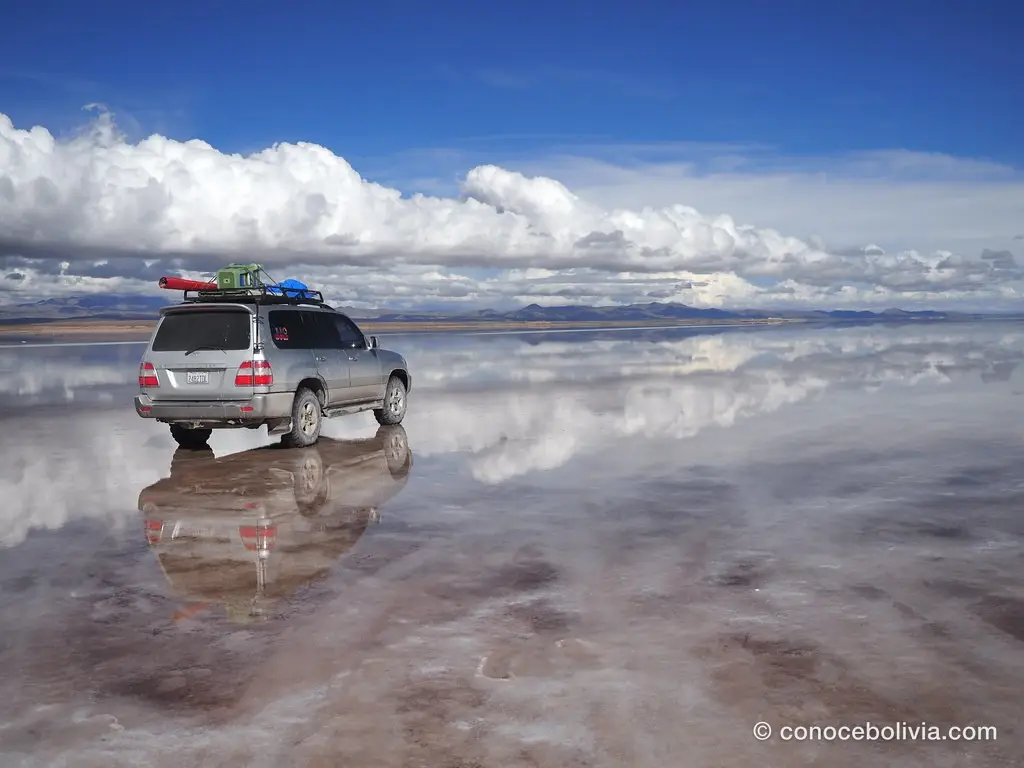 4x4 con equipaje en el techo frente a un banco de nubes espectacular
