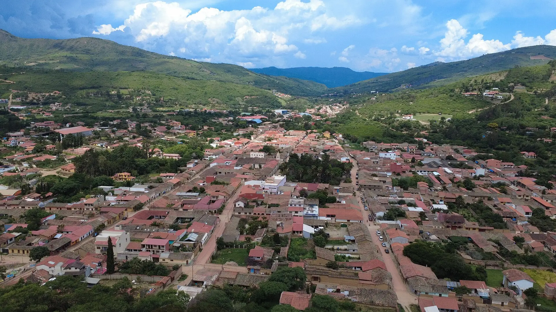 Vista aérea de Samaipata, con sus tejados rojos extendidos en el valle entre colinas verdes